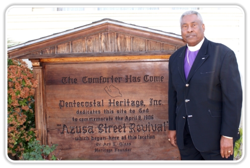 Bisho Ealy in front of Azusa Street Revival sign at Bonnie Brae House